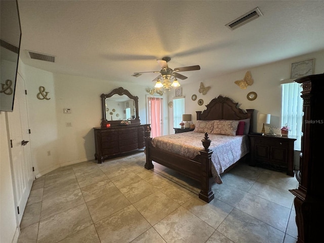 bedroom with a textured ceiling, ceiling fan, and light tile floors