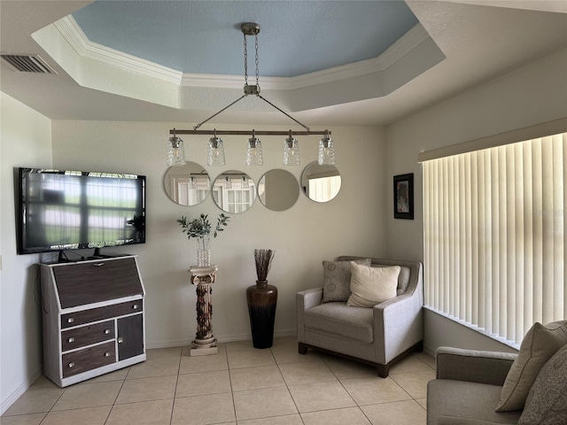 living area featuring a tray ceiling, crown molding, and light tile floors