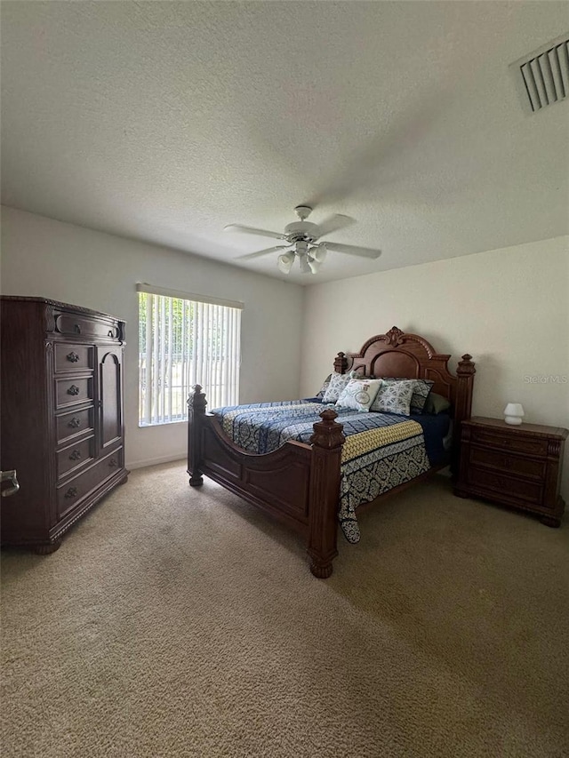 carpeted bedroom featuring a textured ceiling and ceiling fan