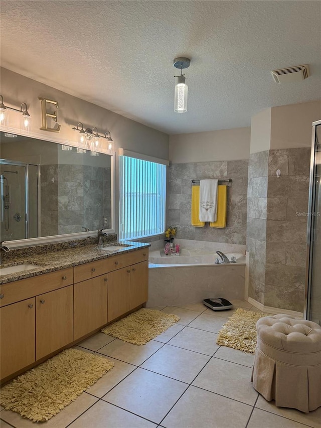 bathroom featuring tile flooring, shower with separate bathtub, and a textured ceiling