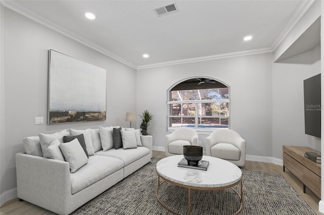 living room with hardwood / wood-style floors, ceiling fan, and crown molding