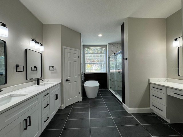 bathroom with plus walk in shower, a textured ceiling, vanity, and tile patterned floors