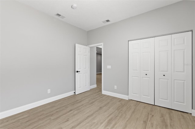 unfurnished bedroom with a closet and light hardwood / wood-style floors