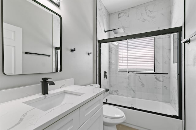 full bathroom with shower / bath combination with glass door, vanity, and toilet