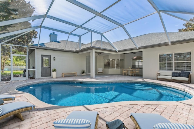 view of swimming pool featuring a patio area, ceiling fan, and glass enclosure