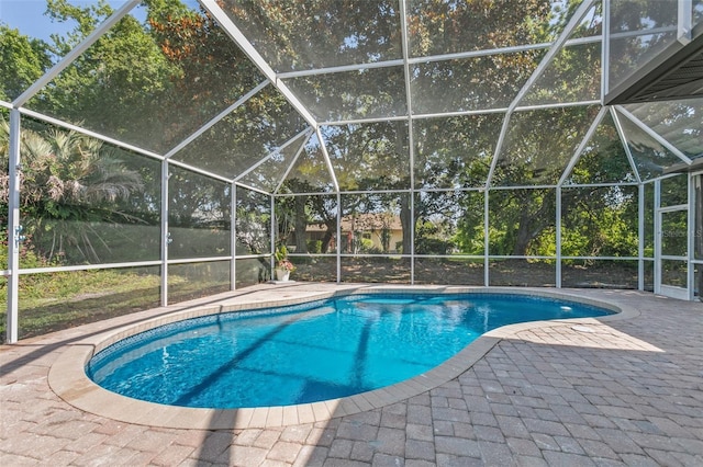 view of swimming pool with glass enclosure and a patio