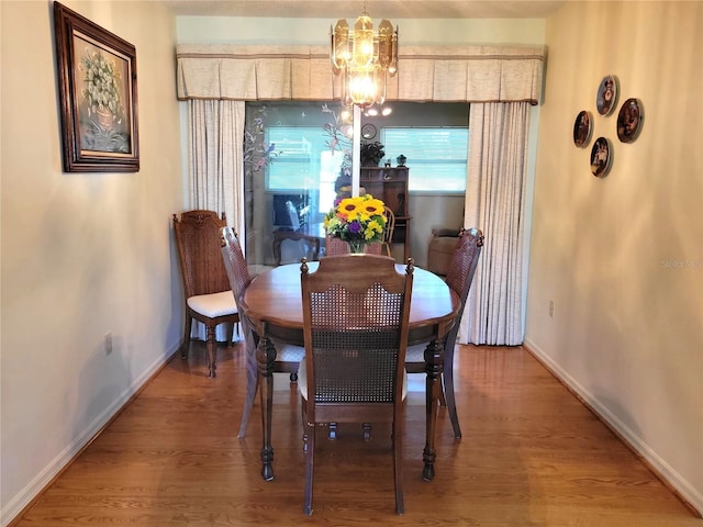 dining room with a chandelier and wood-type flooring