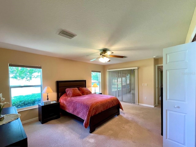 bedroom with a textured ceiling, carpet, and ceiling fan