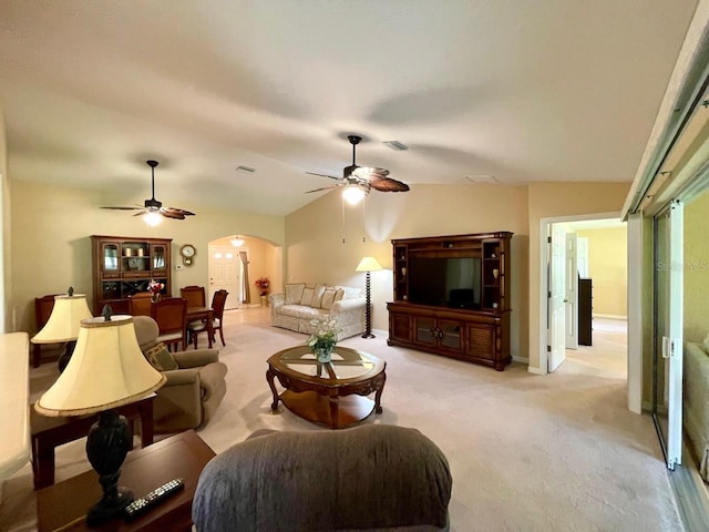 carpeted living room with ceiling fan and vaulted ceiling