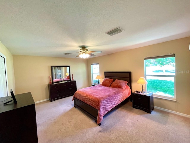 carpeted bedroom featuring a textured ceiling and ceiling fan