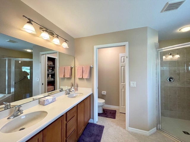 bathroom featuring walk in shower, tile patterned floors, double sink vanity, and toilet