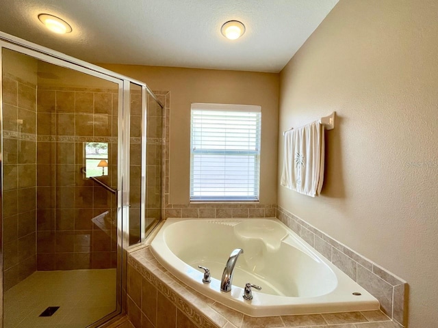 bathroom featuring plus walk in shower and a textured ceiling