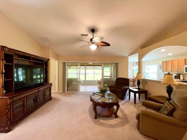 living room with vaulted ceiling, ceiling fan, a healthy amount of sunlight, and light colored carpet