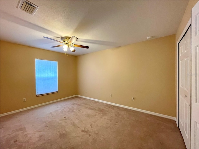 unfurnished bedroom featuring carpet, ceiling fan, and a closet