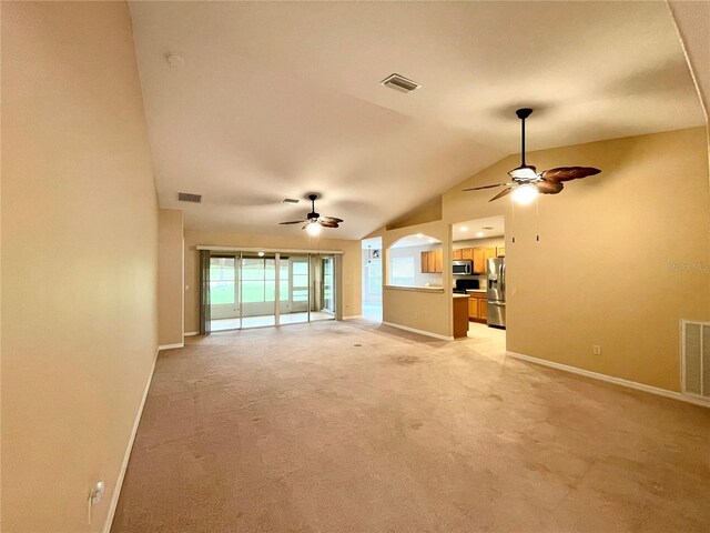 unfurnished living room featuring lofted ceiling, light carpet, and ceiling fan