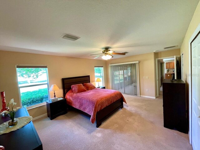 bedroom with multiple windows, ceiling fan, and carpet flooring