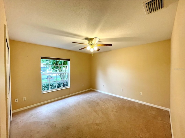 carpeted empty room featuring a textured ceiling and ceiling fan