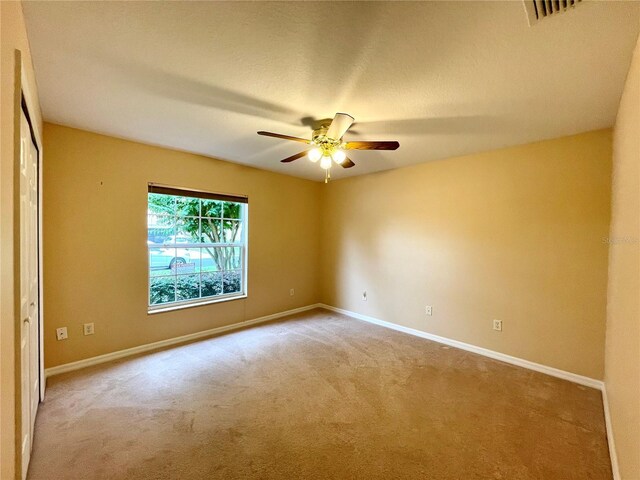 unfurnished room featuring ceiling fan and carpet flooring