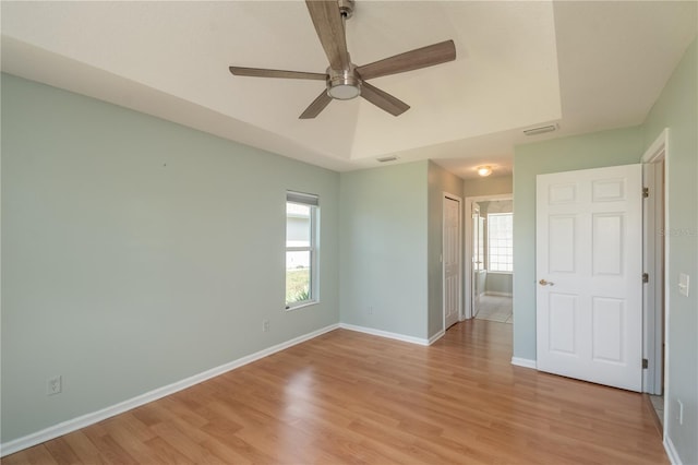 unfurnished room featuring a healthy amount of sunlight, ceiling fan, and light hardwood / wood-style flooring