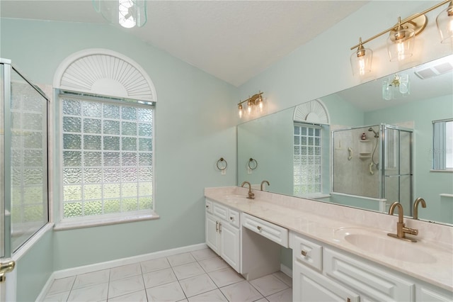 bathroom featuring tile flooring, double sink, vanity with extensive cabinet space, a shower with door, and vaulted ceiling