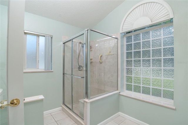 bathroom with a textured ceiling, tile flooring, and an enclosed shower