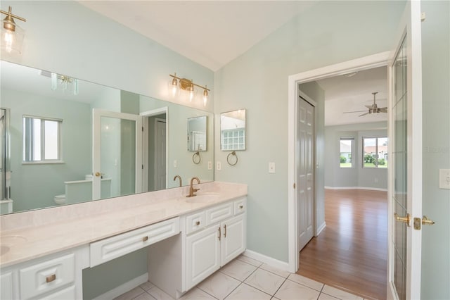 bathroom featuring vaulted ceiling, ceiling fan, toilet, tile flooring, and vanity