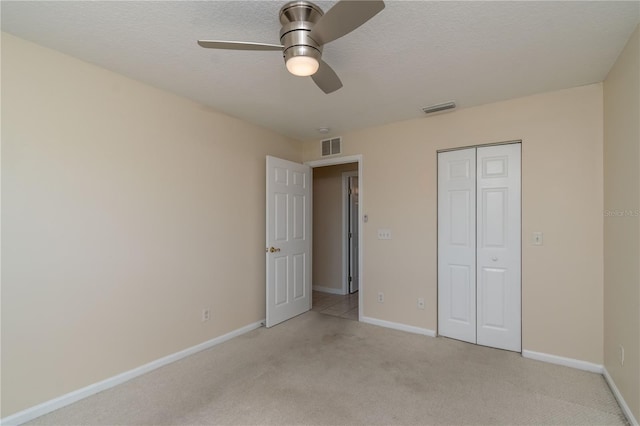 unfurnished bedroom featuring light carpet, a closet, and ceiling fan