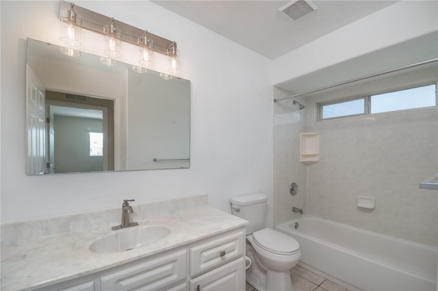 full bathroom featuring a wealth of natural light, tiled shower / bath, tile floors, vanity, and toilet