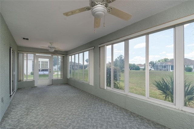 unfurnished sunroom with ceiling fan