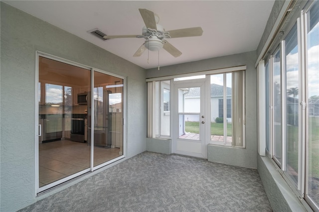 unfurnished sunroom with ceiling fan