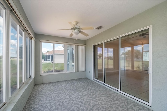 unfurnished sunroom featuring ceiling fan