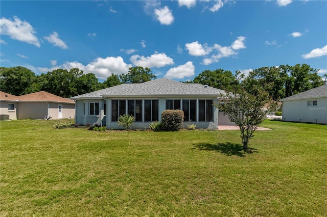 rear view of house with a sunroom and a lawn