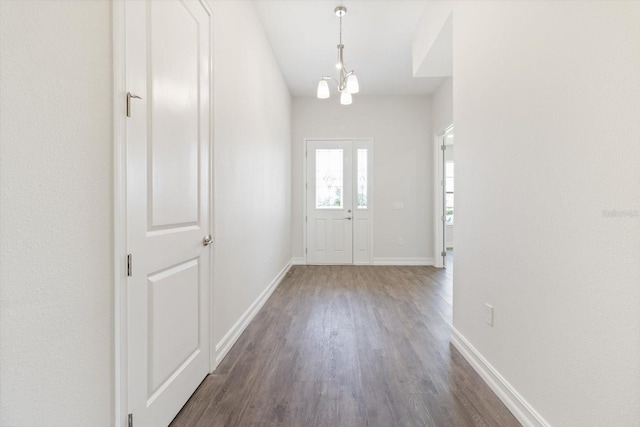 entryway with dark hardwood / wood-style flooring and an inviting chandelier