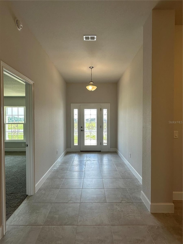 foyer with a wealth of natural light and light tile patterned floors