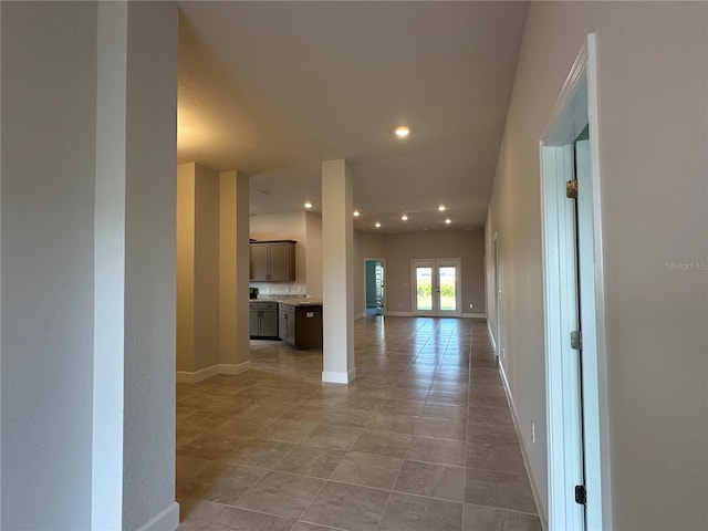 corridor with light tile patterned flooring and french doors