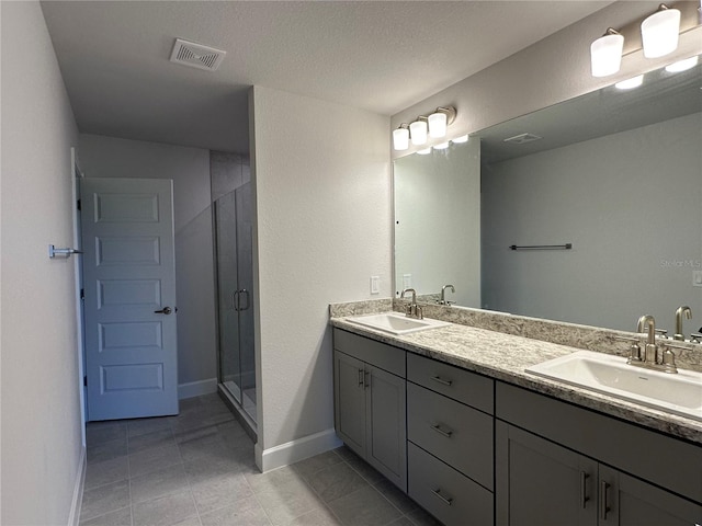 bathroom with tile patterned flooring, an enclosed shower, vanity, and a textured ceiling