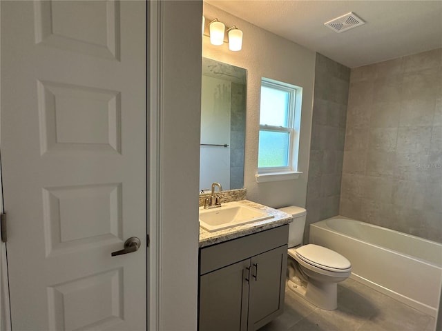 full bathroom with tiled shower / bath, vanity, and toilet