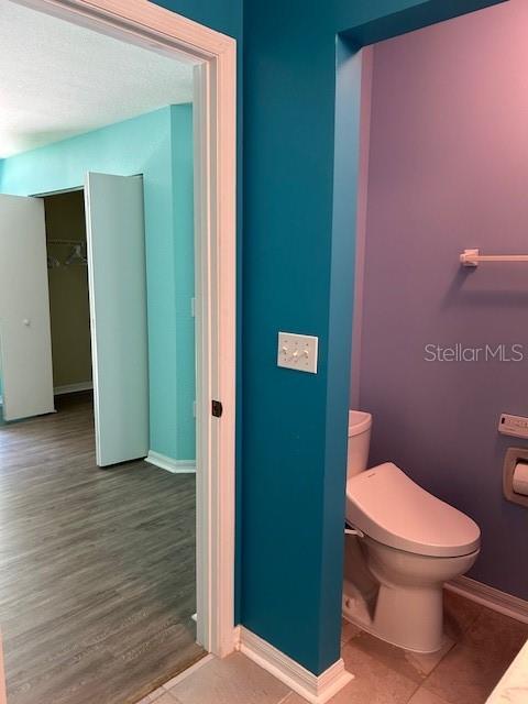 bathroom with hardwood / wood-style flooring and toilet