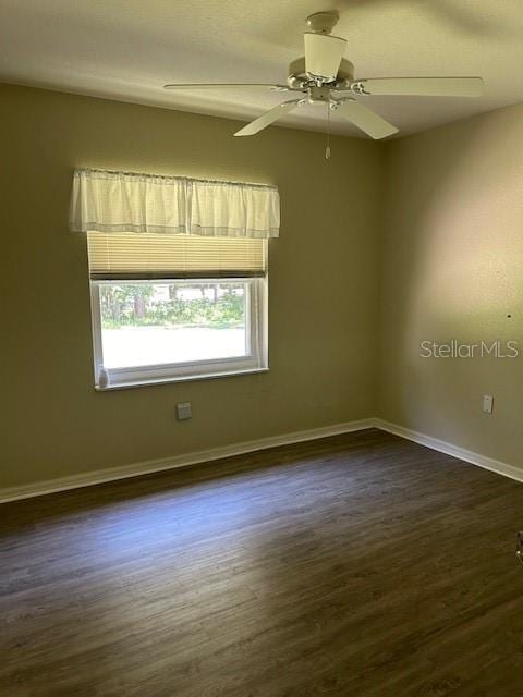 unfurnished room featuring dark hardwood / wood-style floors and ceiling fan