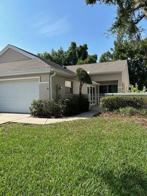 single story home featuring a garage and a front yard