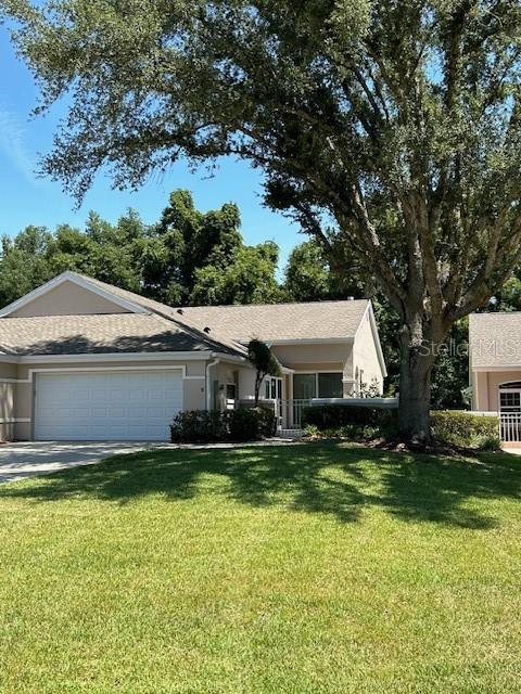 ranch-style house with a garage and a front lawn