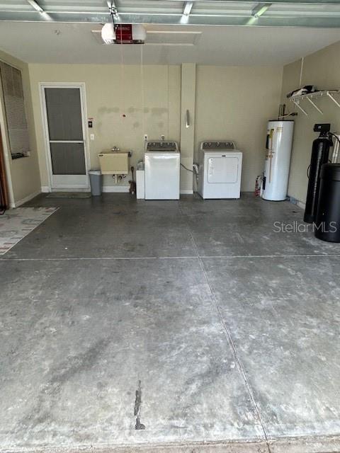 garage featuring sink, a garage door opener, and water heater