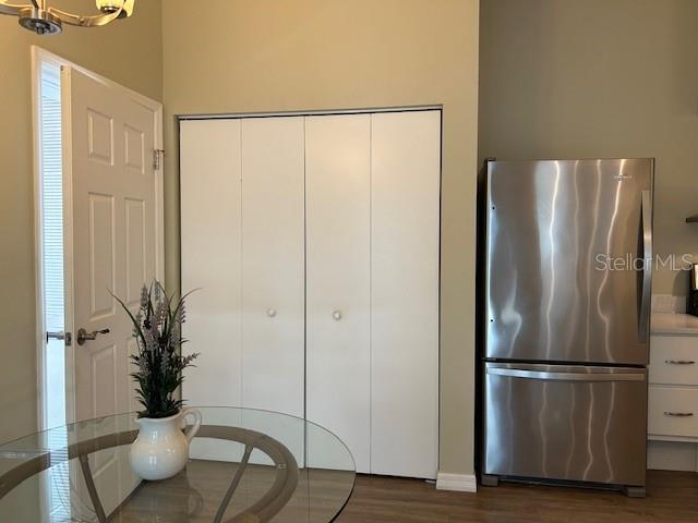 kitchen with dark hardwood / wood-style flooring, stainless steel fridge, and white cabinets