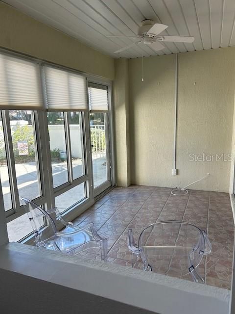 unfurnished room with wooden ceiling and ceiling fan