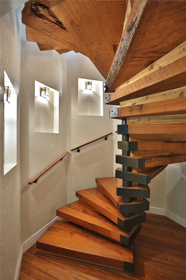 stairway featuring vaulted ceiling and hardwood / wood-style floors