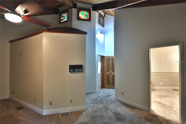 interior space with beamed ceiling, ceiling fan, and wooden ceiling