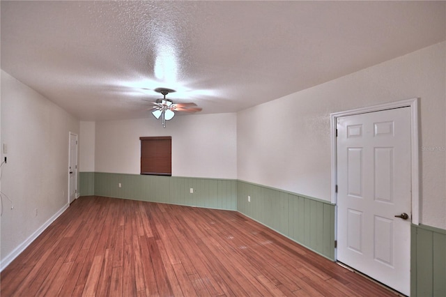 unfurnished room featuring a textured ceiling, ceiling fan, and hardwood / wood-style floors