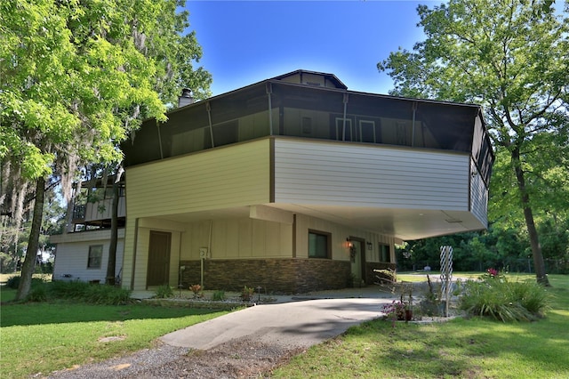 view of front of home with a carport and a front lawn