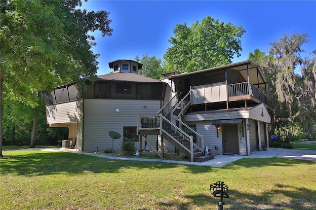 back of house with a garage and a lawn