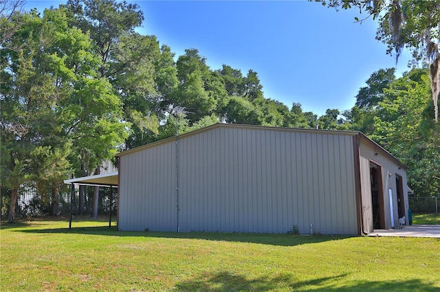 view of side of property featuring a carport and a lawn